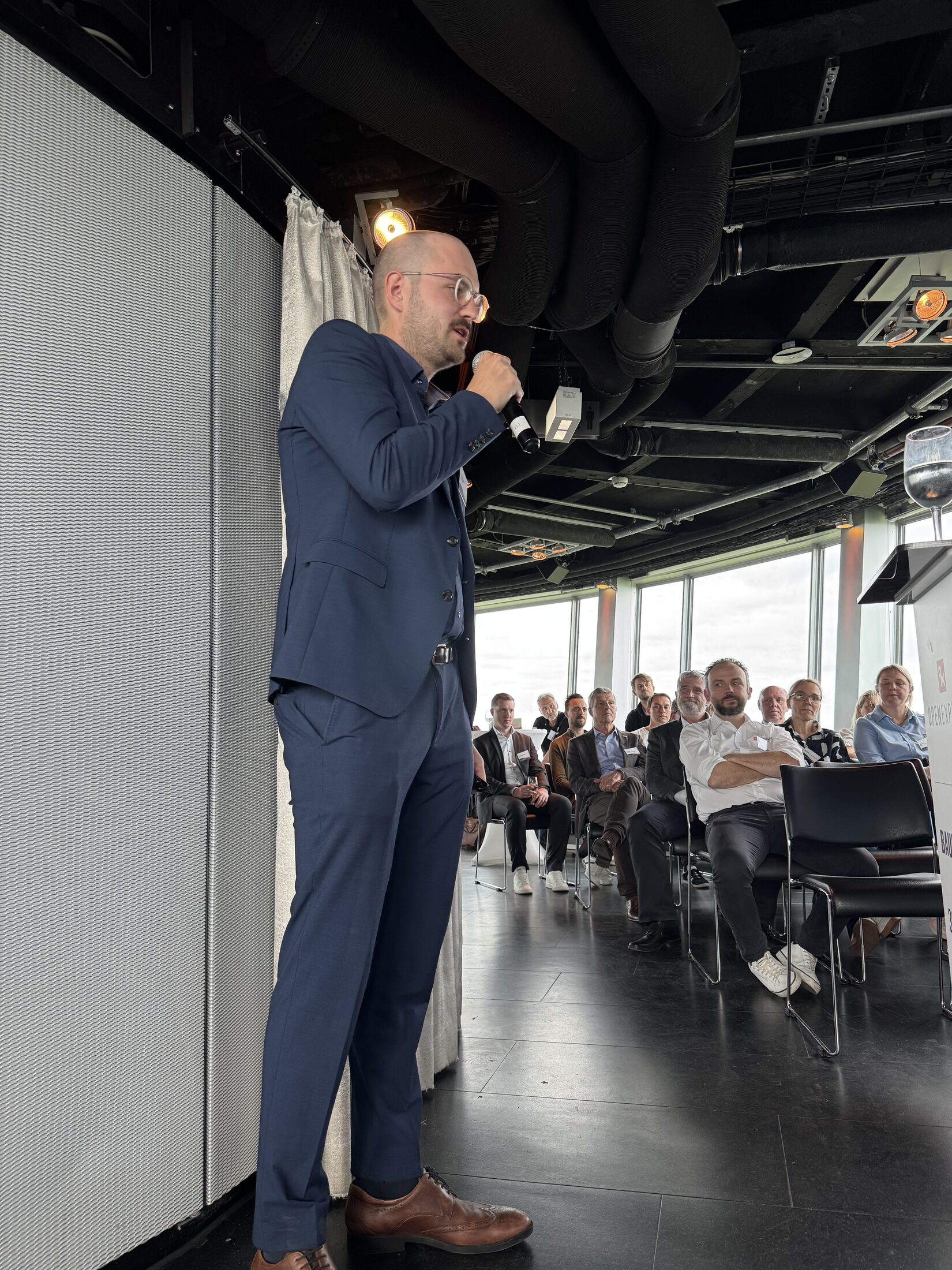 Impulsvortrag auf der Eventebene — Speaker mit Publikum und Blick über Stuttgart
